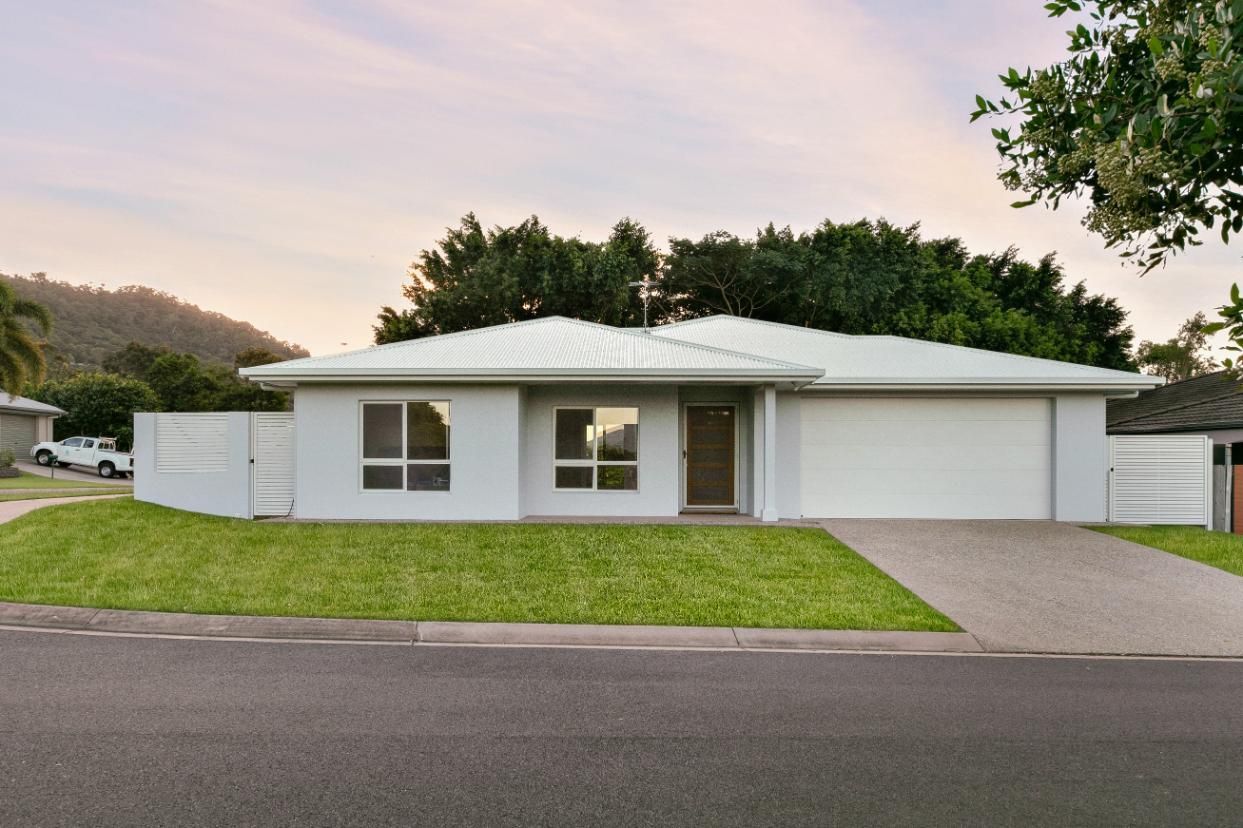 A White House With a Lush Green Lawn in Front of It — Ashlee Jones Homes in Gordonvale, QLD