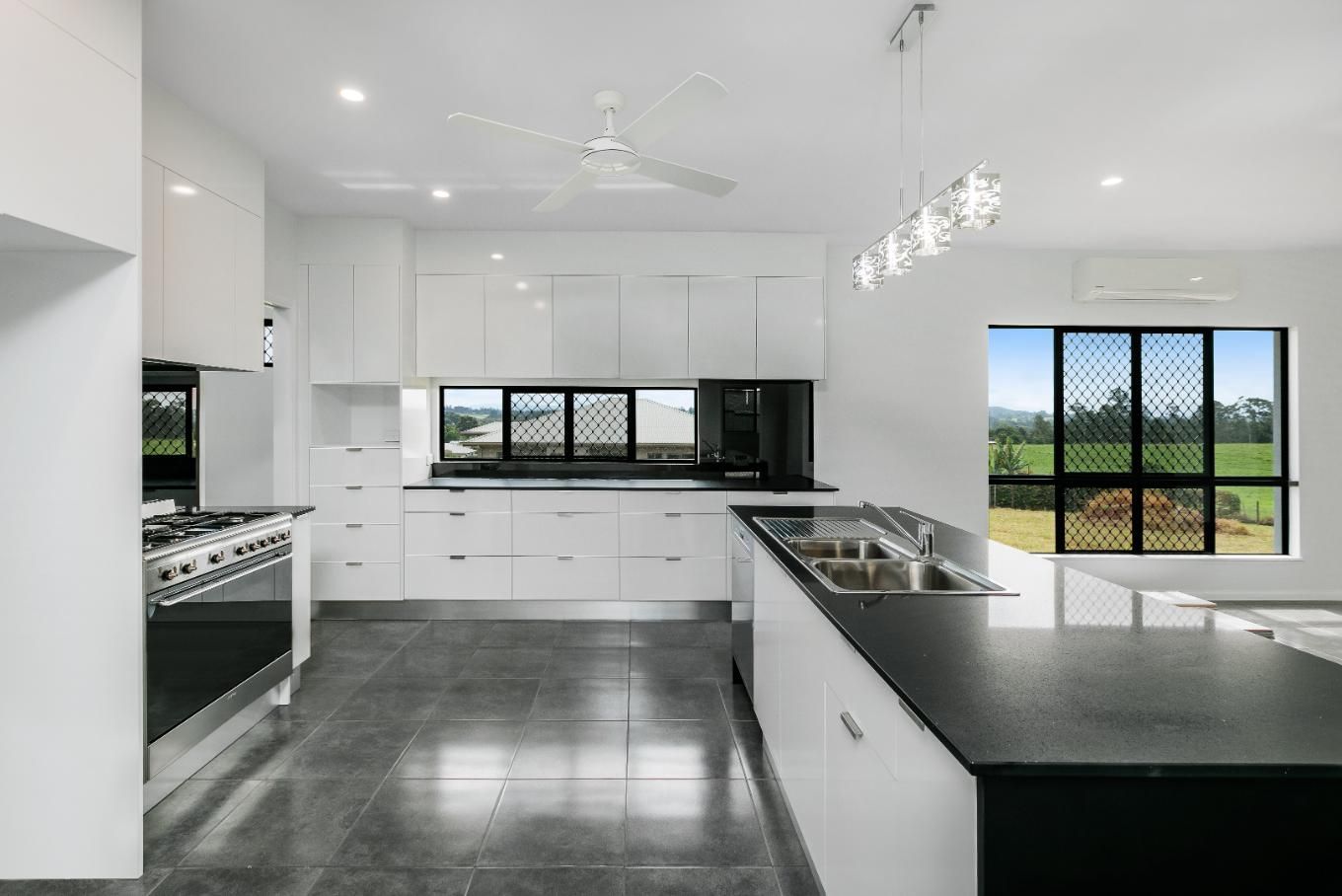 A Kitchen With White Cabinets and Black Countertops — Ashlee Jones Homes in Gordonvale, QLD