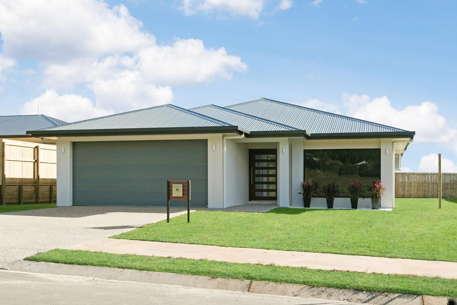 A White House With a Gray Roof and a Fence in the Background — Ashlee Jones Homes in Gordonvale, QLD