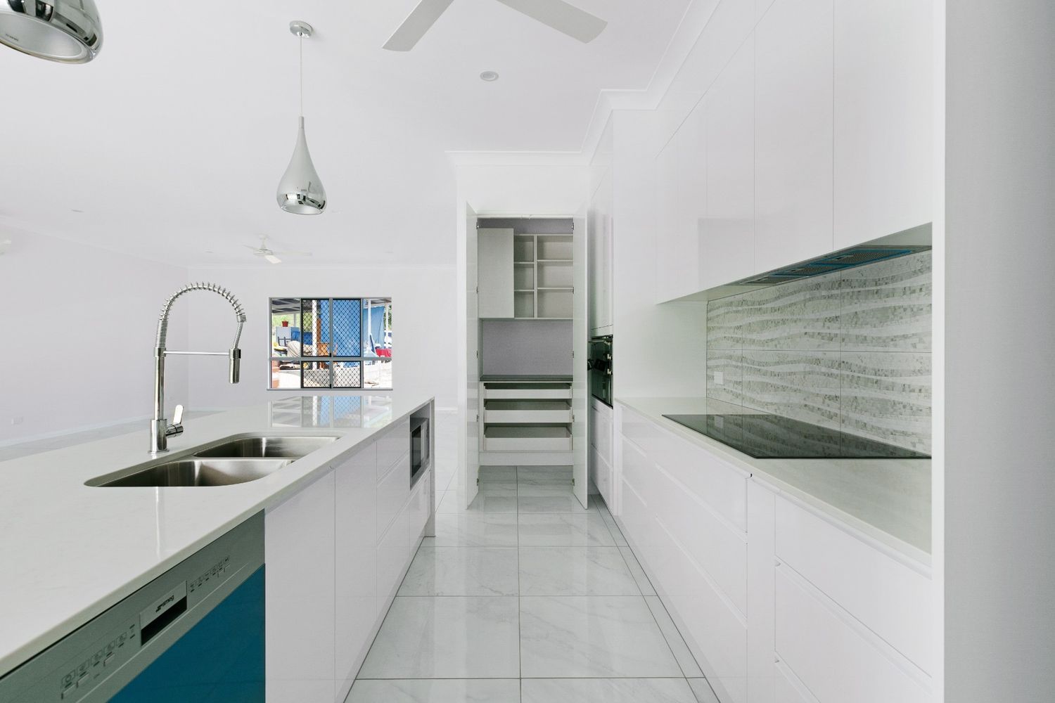 A Kitchen With White Cabinets and a Blue Dishwasher — Ashlee Jones Homes in Gordonvale, QLD