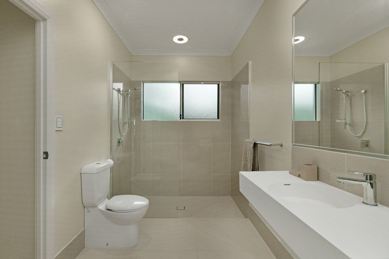 A Bathroom With a Toilet, Sink, and Shower — Ashlee Jones Homes in Gordonvale, QLD