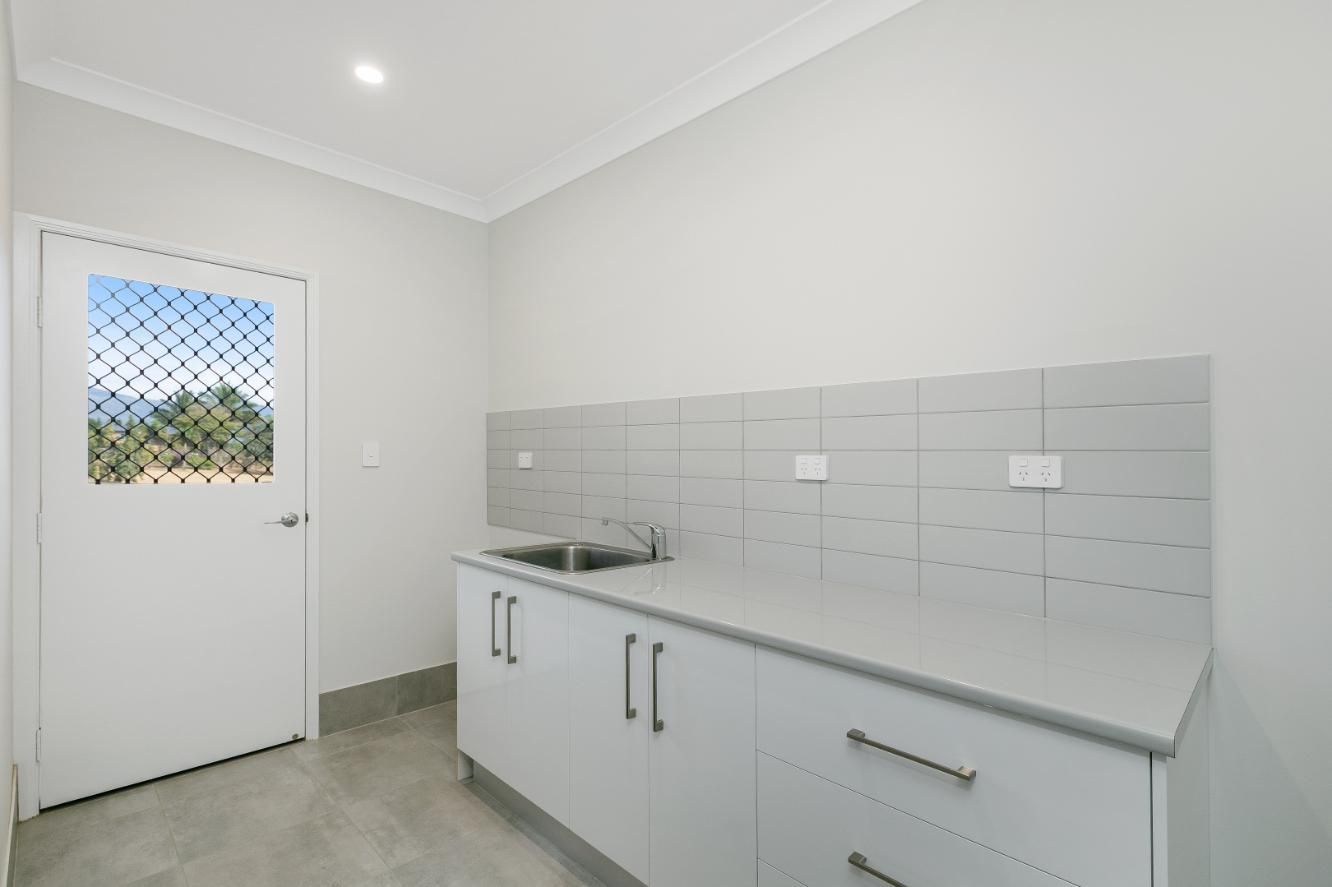 A Kitchen With White Cabinets, a Sink and a Window — Ashlee Jones Homes in Gordonvale, QLD