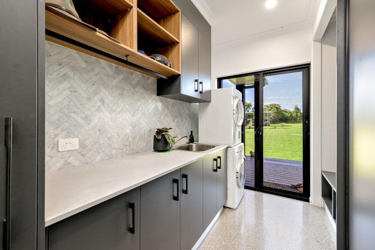 A Kitchen With a Sink, Refrigerator, and Sliding Glass Door — Ashlee Jones Homes in Gordonvale, QLD