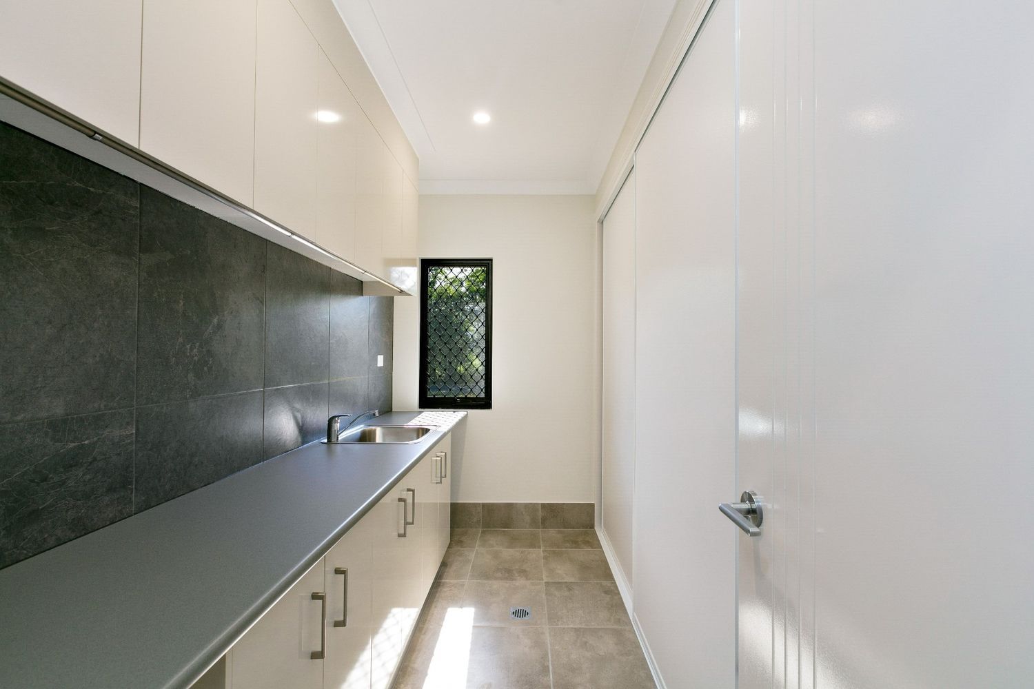 A Kitchen With a Sink, Cabinets, and a Window — Ashlee Jones Homes in Gordonvale, QLD