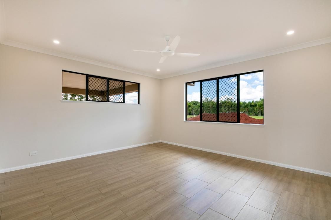 An Empty Room With Two Windows and a Ceiling Fan — Ashlee Jones Homes in Gordonvale, QLD