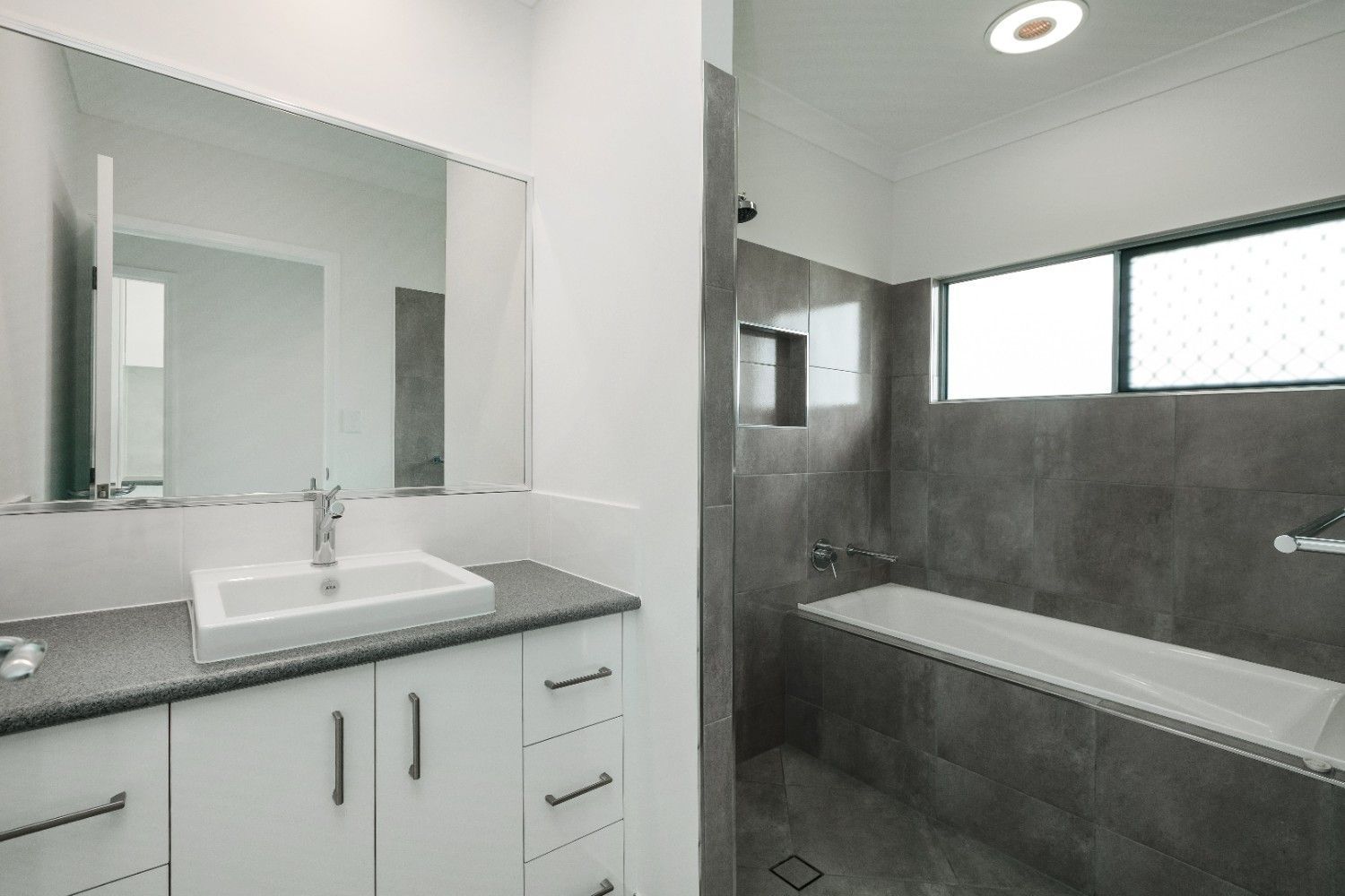 A Bathroom With a Sink, Tub and Mirror — Ashlee Jones Homes in Gordonvale, QLD