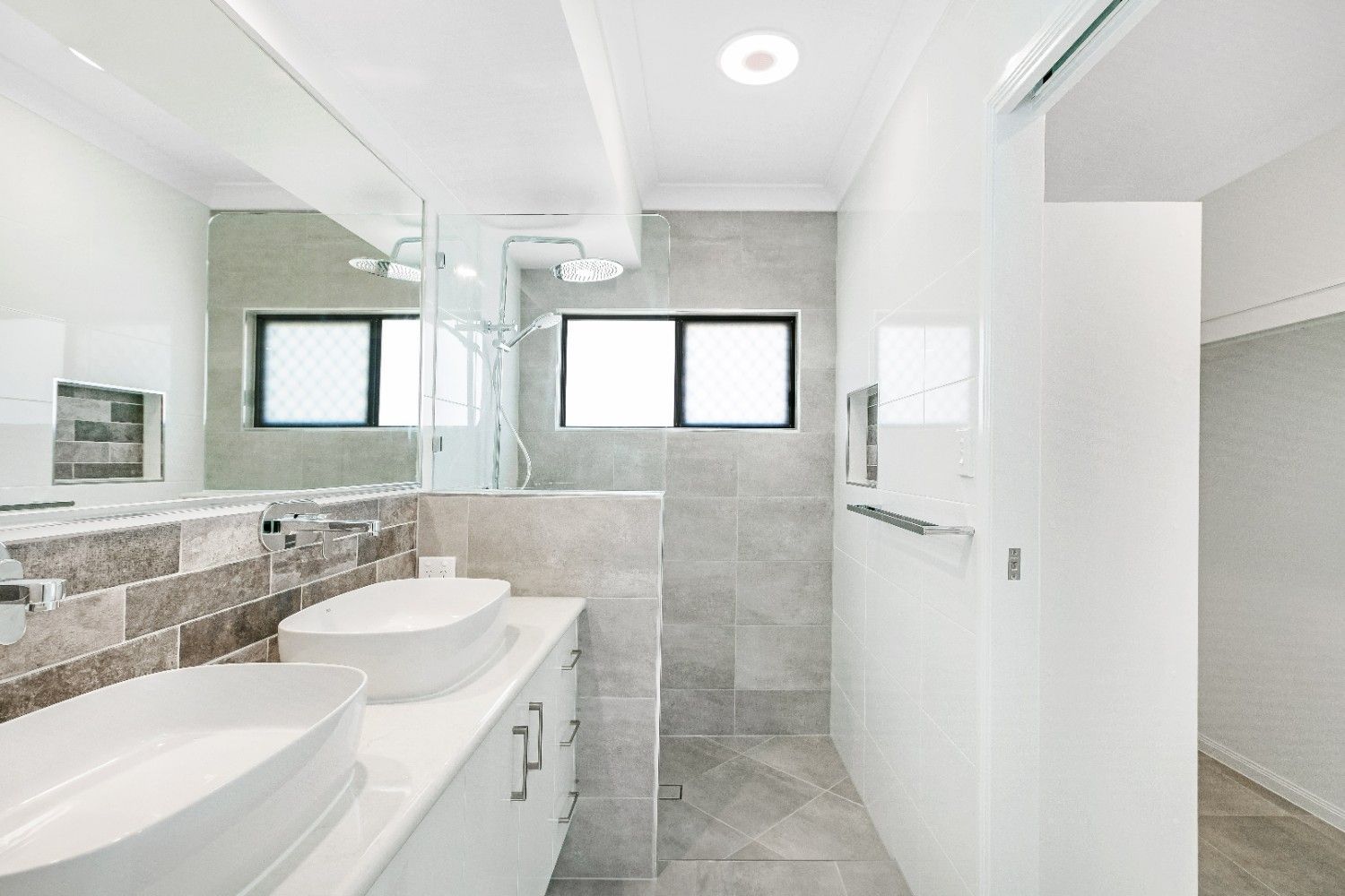 A Bathroom With Two Sinks, a Shower and a Mirror — Ashlee Jones Homes in Gordonvale, QLD