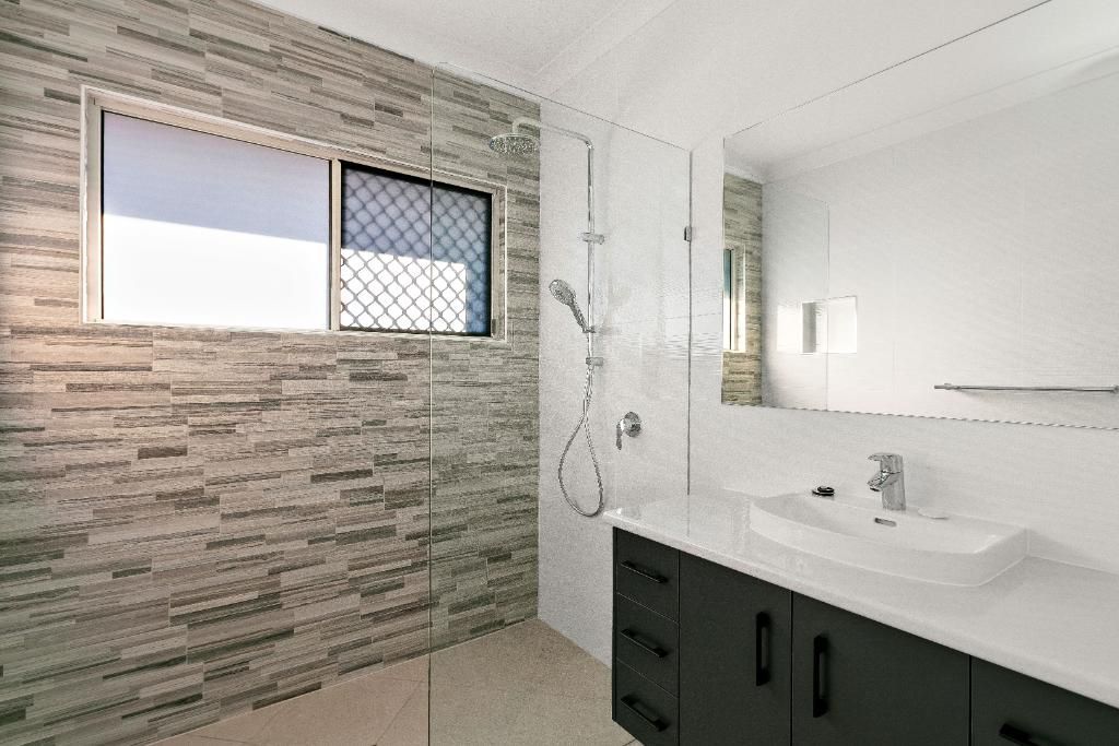 A Bathroom With a Sink, Mirror and Shower — Ashlee Jones Homes in Gordonvale, QLD