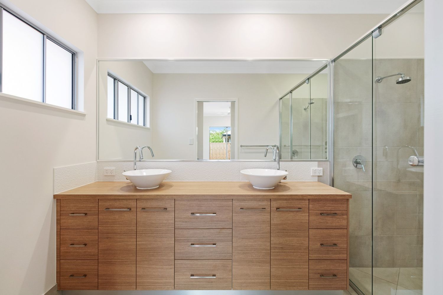 A Bathroom With Two Sinks and a Walk in Shower — Ashlee Jones Homes in Gordonvale, QLD
