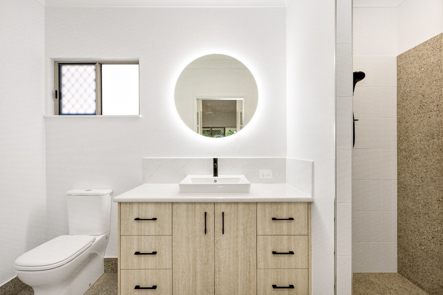 A Bathroom With a Toilet, Sink, Mirror and Shower — Ashlee Jones Homes in Gordonvale, QLD