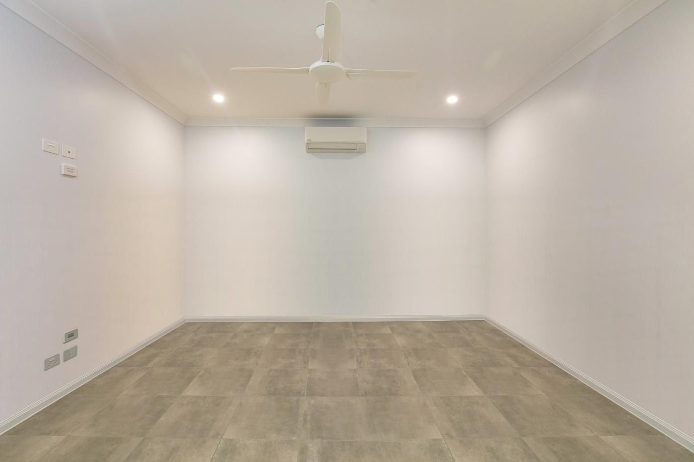 An Empty Room With Hardwood Floors and a Ceiling Fan — Ashlee Jones Homes in Gordonvale, QLD