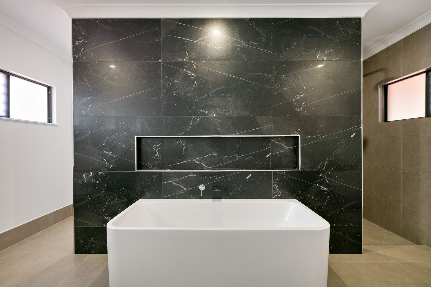 A Bathroom With a Black Marble Wall and a White Bathtub — Ashlee Jones Homes in Gordonvale, QLD