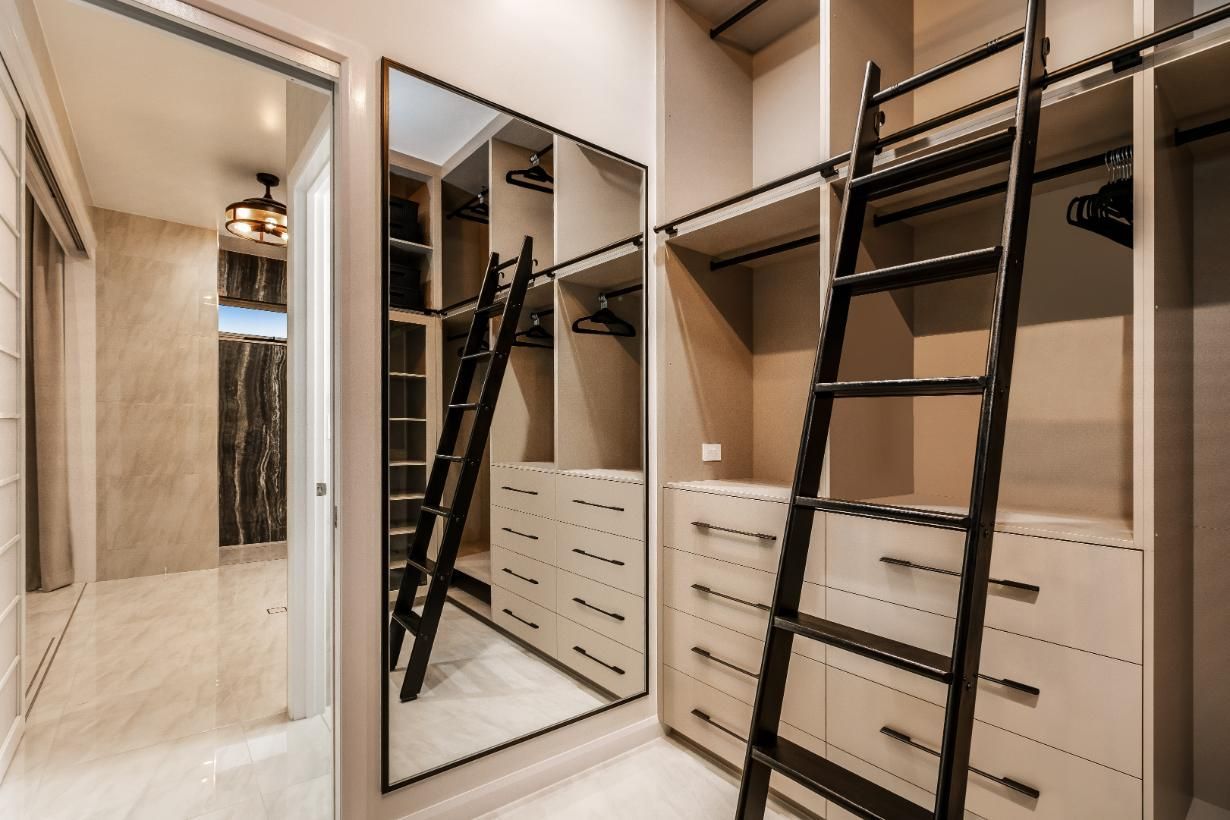 A Walk in Closet With a Ladder and a Large Mirror — Ashlee Jones Homes in Gordonvale, QLD