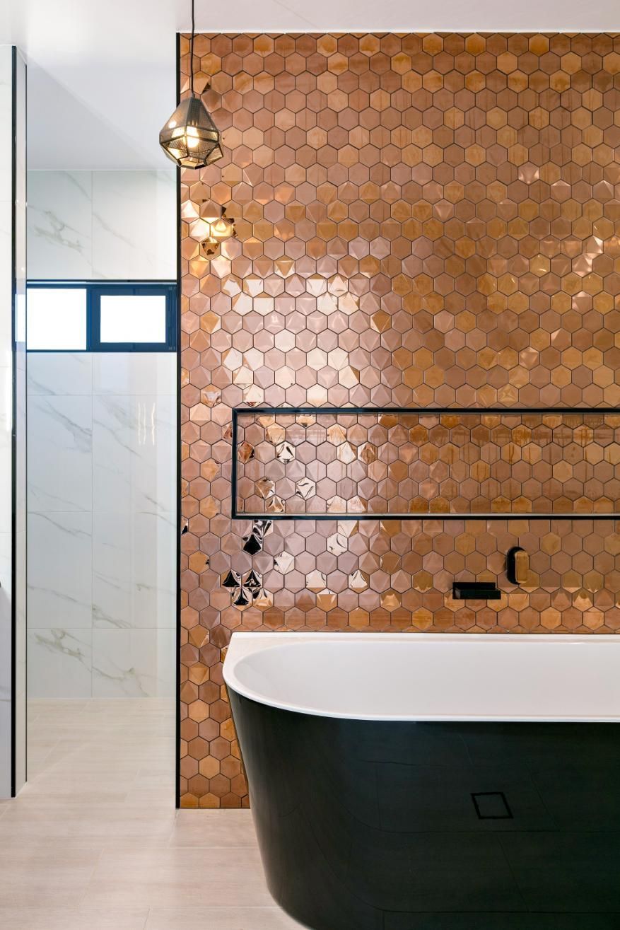 A Bathroom With Copper Tiles and a Black Tub — Ashlee Jones Homes in Gordonvale, QLD