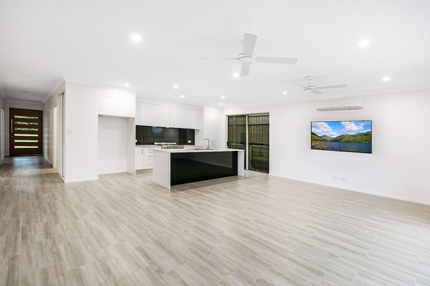 A Living Room With Hardwood Floors, a Kitchen — Ashlee Jones Homes in Gordonvale, QLD