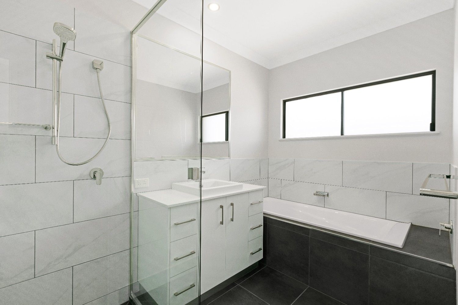 A Bathroom With a Shower, Sink, and Bathtub — Ashlee Jones Homes in Gordonvale, QLD