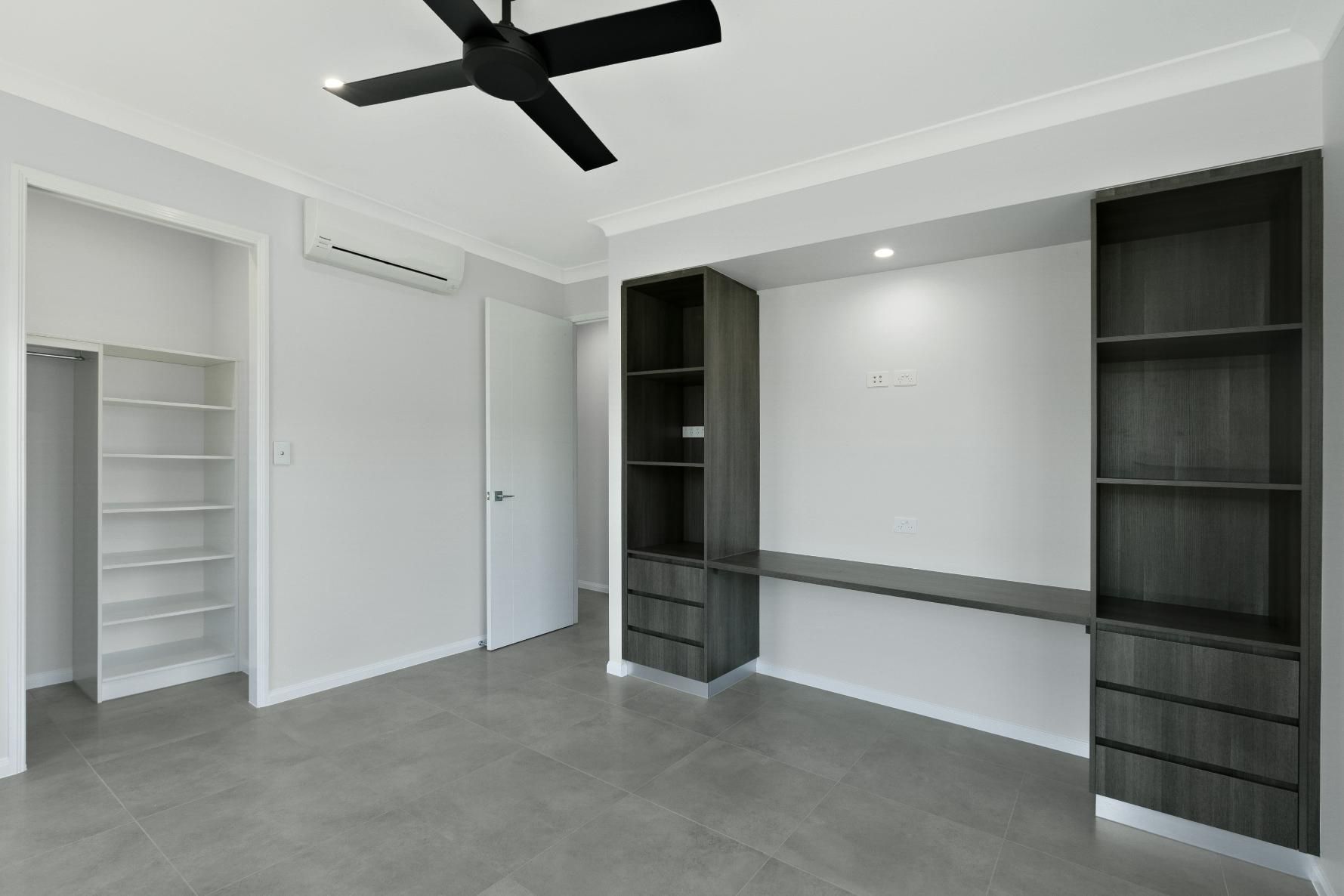 An Empty Room With a Ceiling Fan and Shelves — Ashlee Jones Homes in Gordonvale, QLD