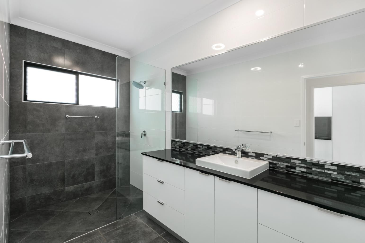 A Bathroom With a Sink and a Walk in Shower — Ashlee Jones Homes in Gordonvale, QLD