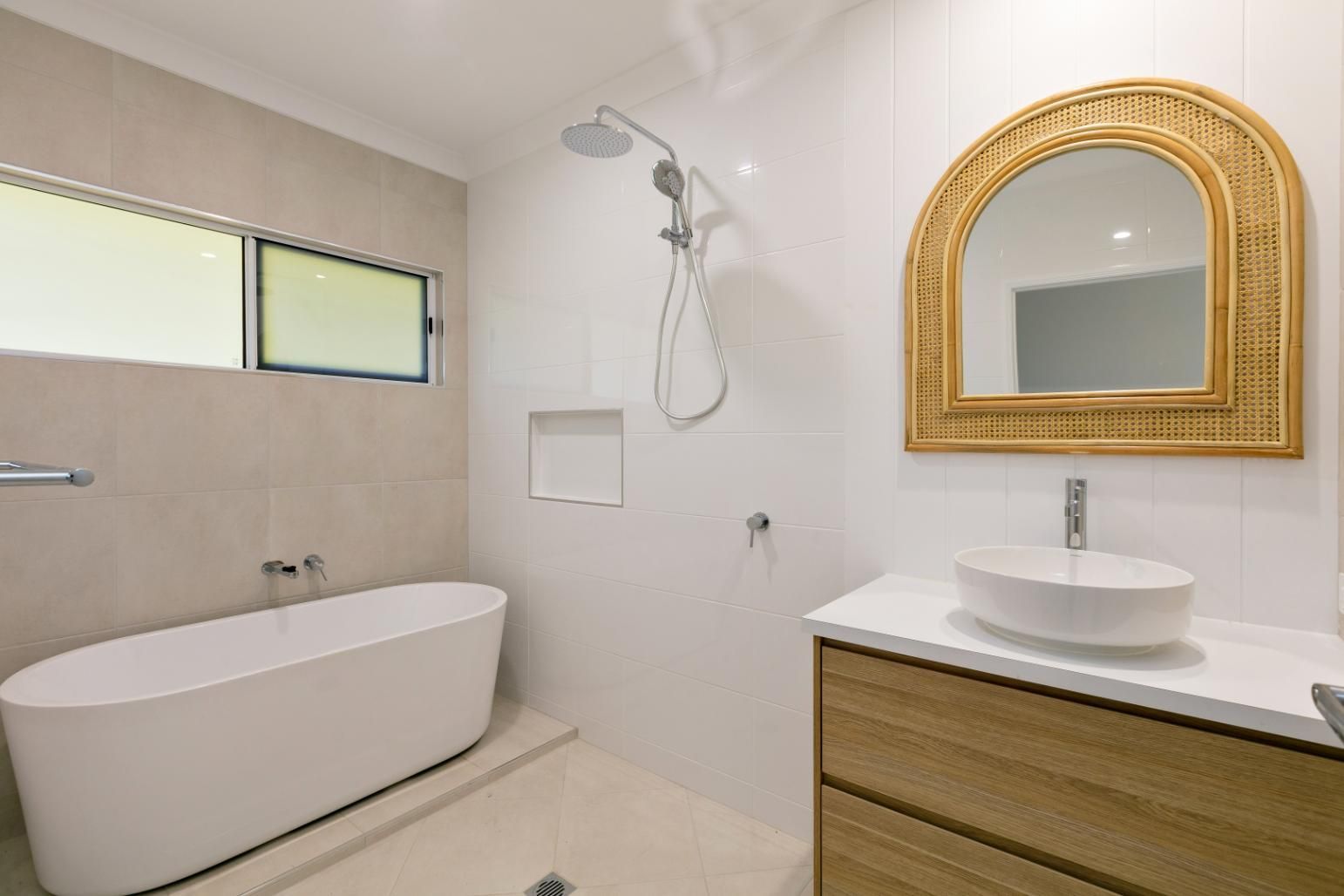 A Bathroom With a Bathtub, Sink, Mirror and Shower — Ashlee Jones Homes in Gordonvale, QLD