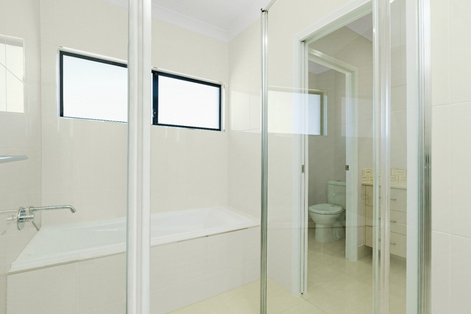 A Bathroom With a Bathtub, Toilet, Sink and Shower — Ashlee Jones Homes in Gordonvale, QLD