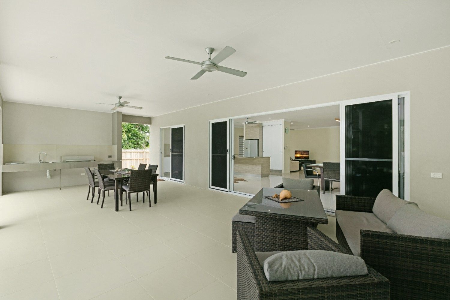 A Living Room With a Table and Chairs and a Ceiling Fan — Ashlee Jones Homes in Gordonvale, QLD