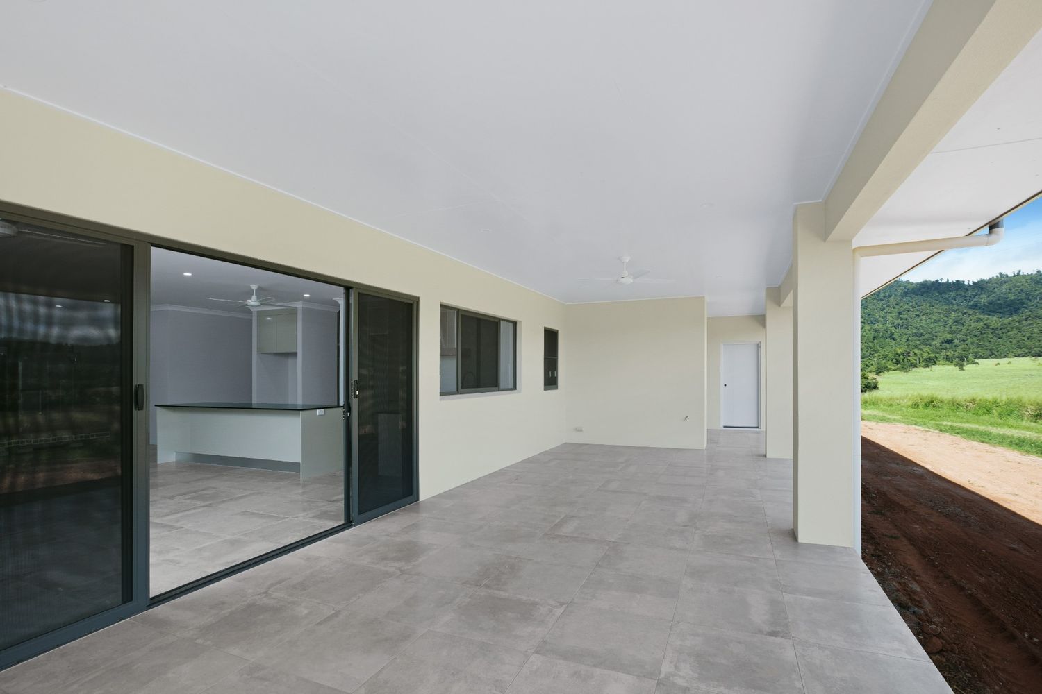 An Empty House With a Large Patio and Sliding Glass Doors — Ashlee Jones Homes in Gordonvale, QLD