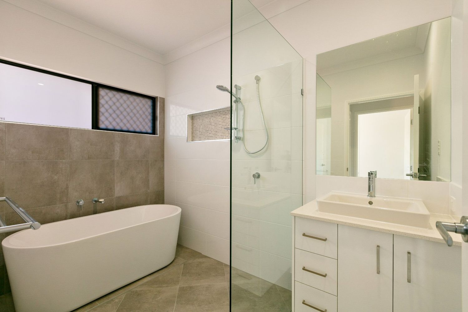 A Bathroom With a Bathtub, Sink and Shower — Ashlee Jones Homes in Gordonvale, QLD
