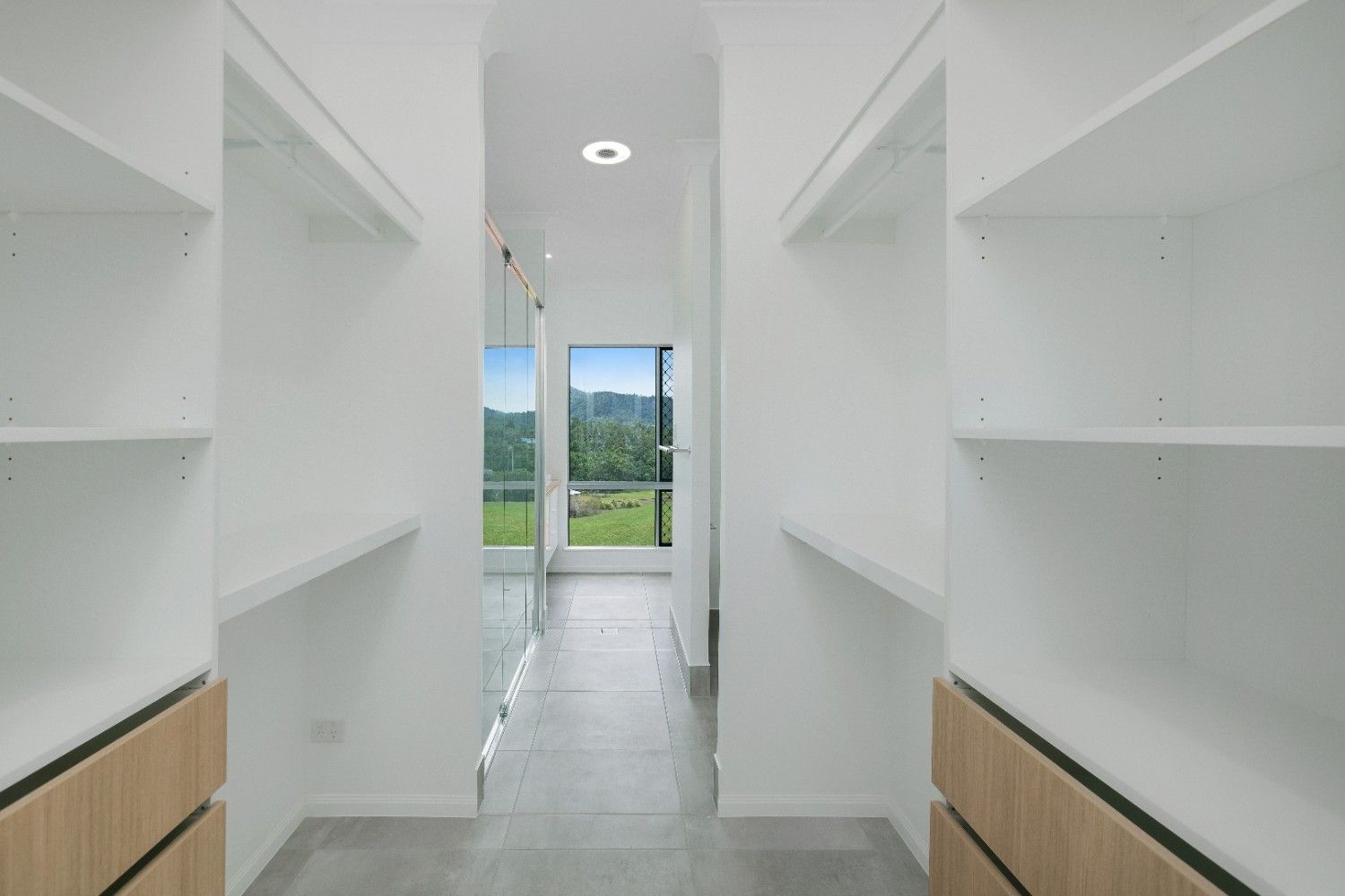 A Walk in Closet With Lots of Shelves and Drawers in a House — Ashlee Jones Homes in Gordonvale, QLD