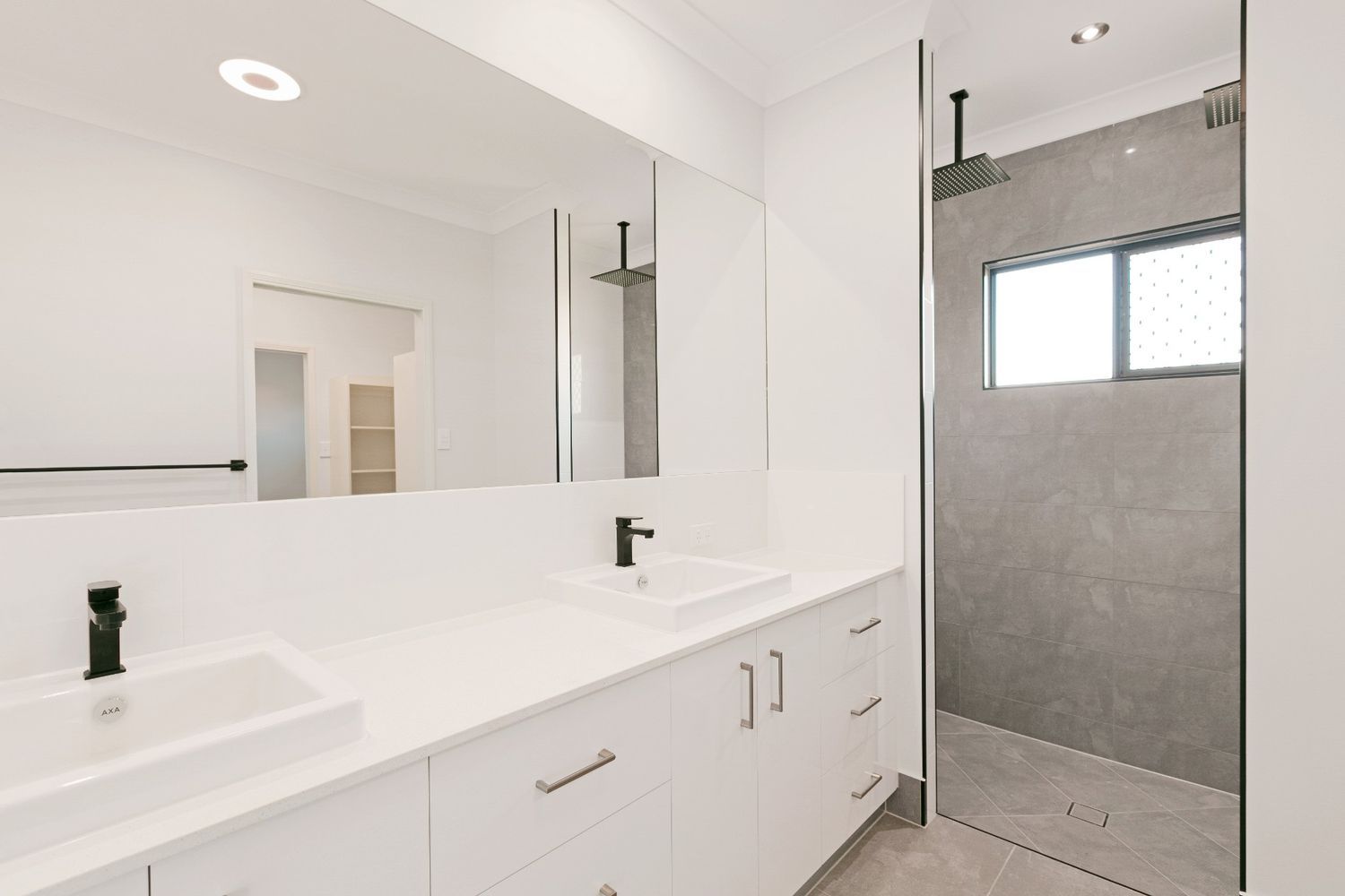 A Bathroom With Two Sinks and a Walk in Shower — Ashlee Jones Homes in Gordonvale, QLD
