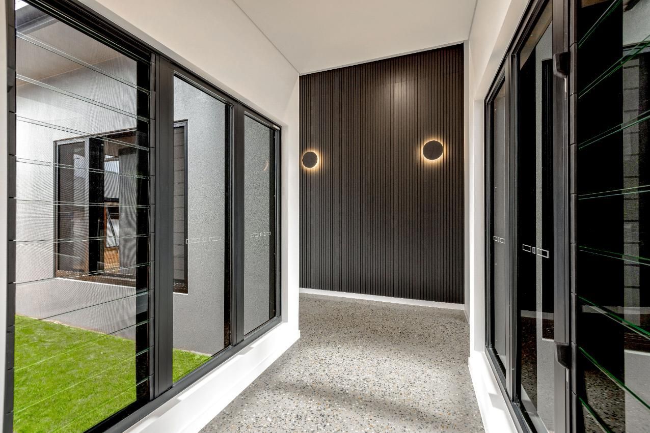 A Hallway with A Lot of Windows and A Light on The Wall — Ashlee Jones Homes in Gordonvale, QLD