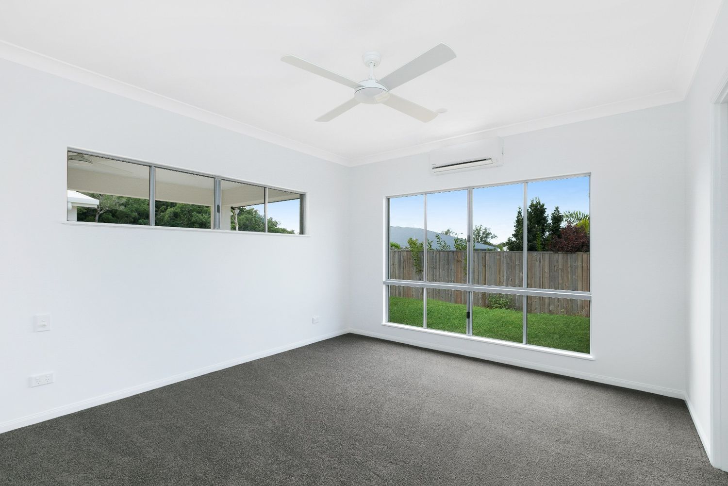 An Empty Room With a Ceiling Fan and a Lot of Windows — Ashlee Jones Homes in Gordonvale, QLD