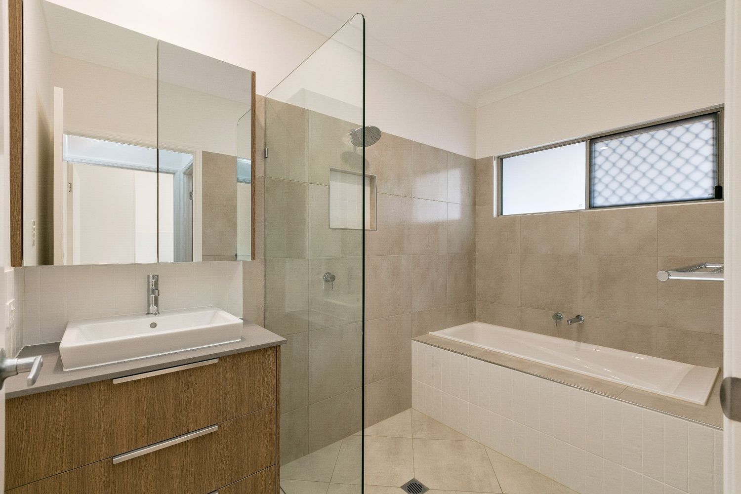 A Bathroom With a Sink, Bathtub and Walk in Shower — Ashlee Jones Homes in Gordonvale, QLD