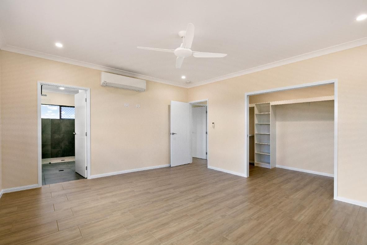 An Empty Living Room With Hardwood Floors and a Ceiling Fan — Ashlee Jones Homes in Gordonvale, QLD