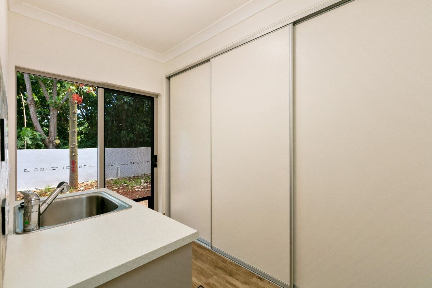 A Kitchen With a Sink and Sliding Glass Doors — Ashlee Jones Homes in Gordonvale, QLD