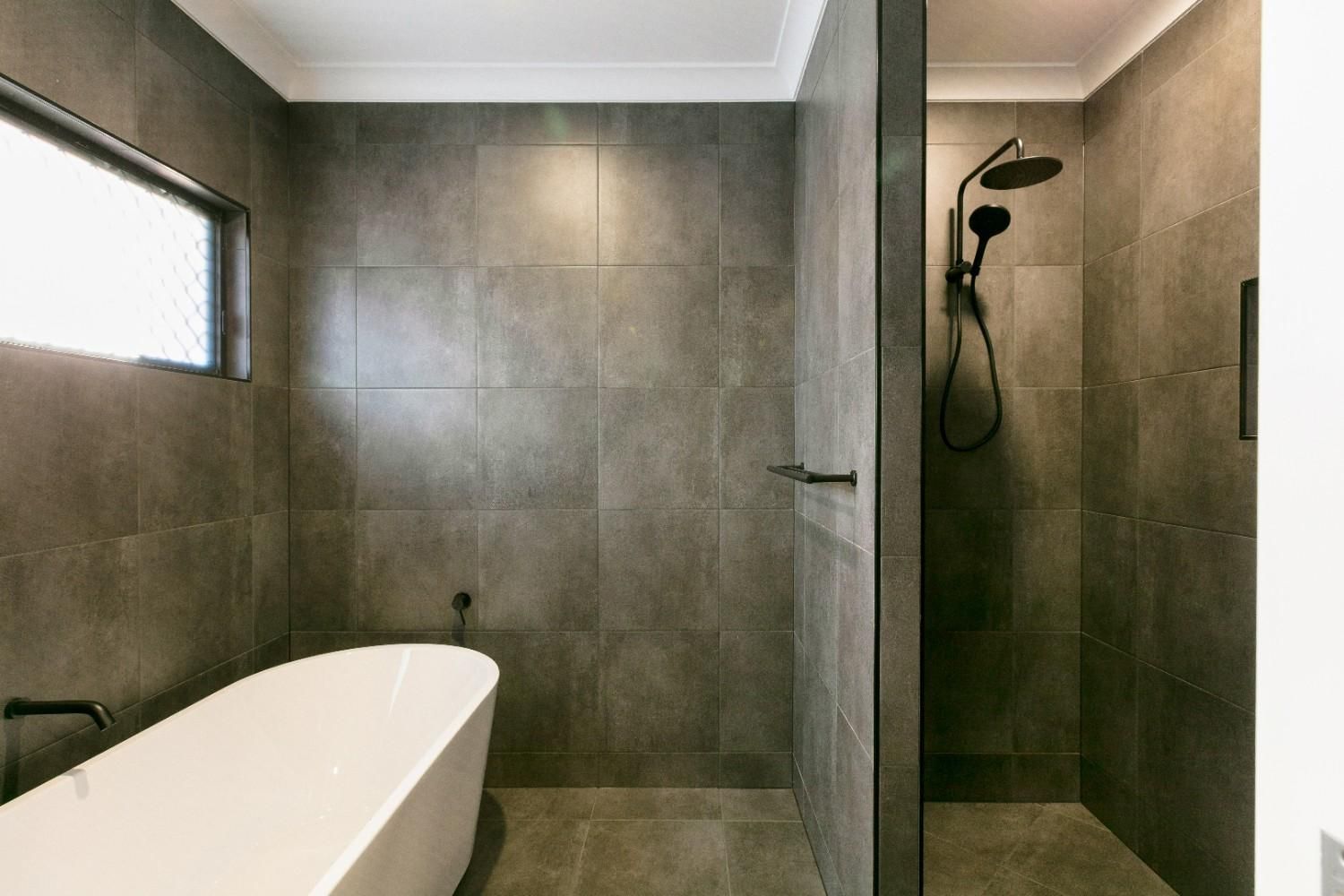 A Bathroom With a Bathtub and a Walk in Shower  — Ashlee Jones Homes in Gordonvale, QLD