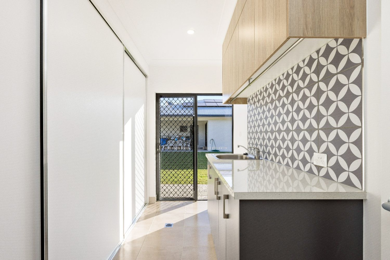 A Kitchen With a Sliding Glass Door Leading to a Backyard — Ashlee Jones Homes in Gordonvale, QLD