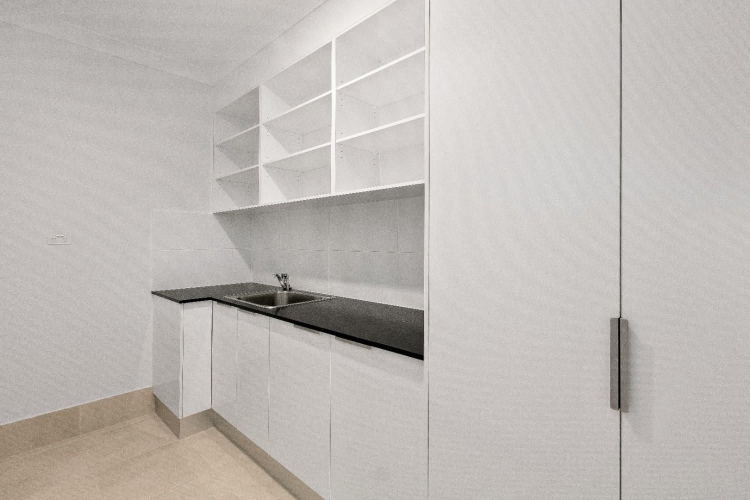 A Kitchen With White Cabinets, Black Counter Tops, and a Sink — Ashlee Jones Homes in Gordonvale, QLD