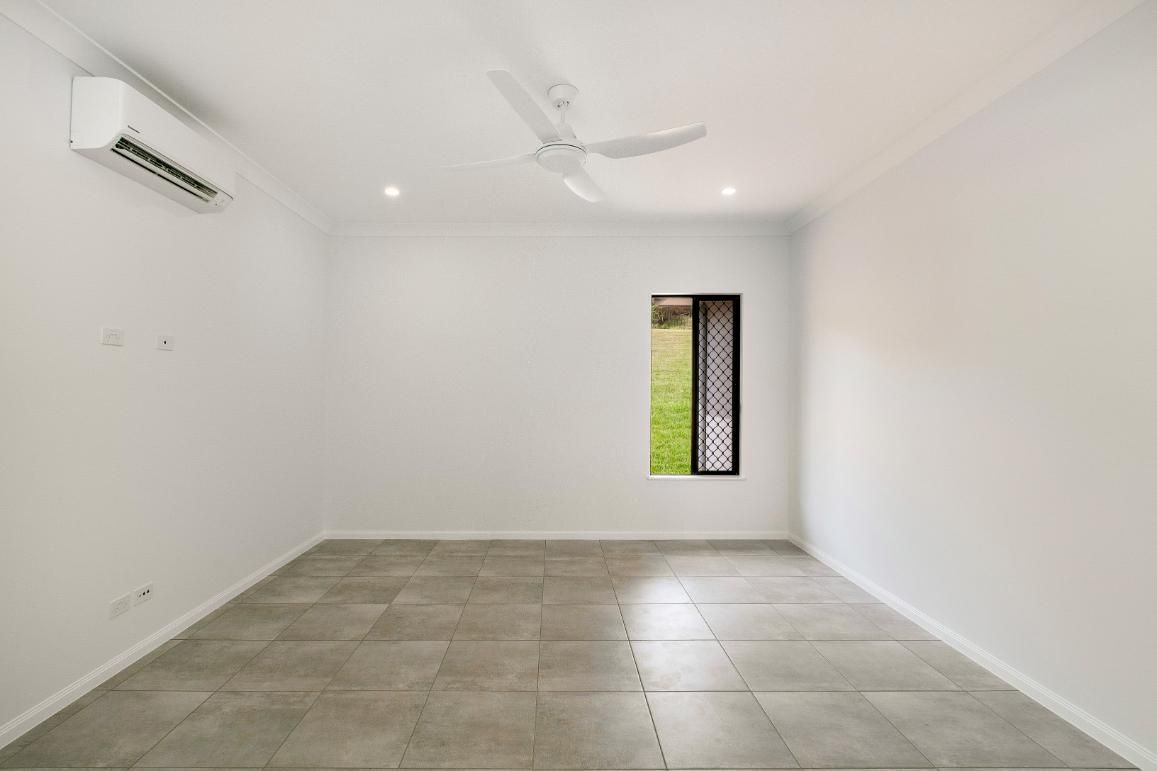 An Empty Room With a Ceiling Fan and a Window — Ashlee Jones Homes in Gordonvale, QLD