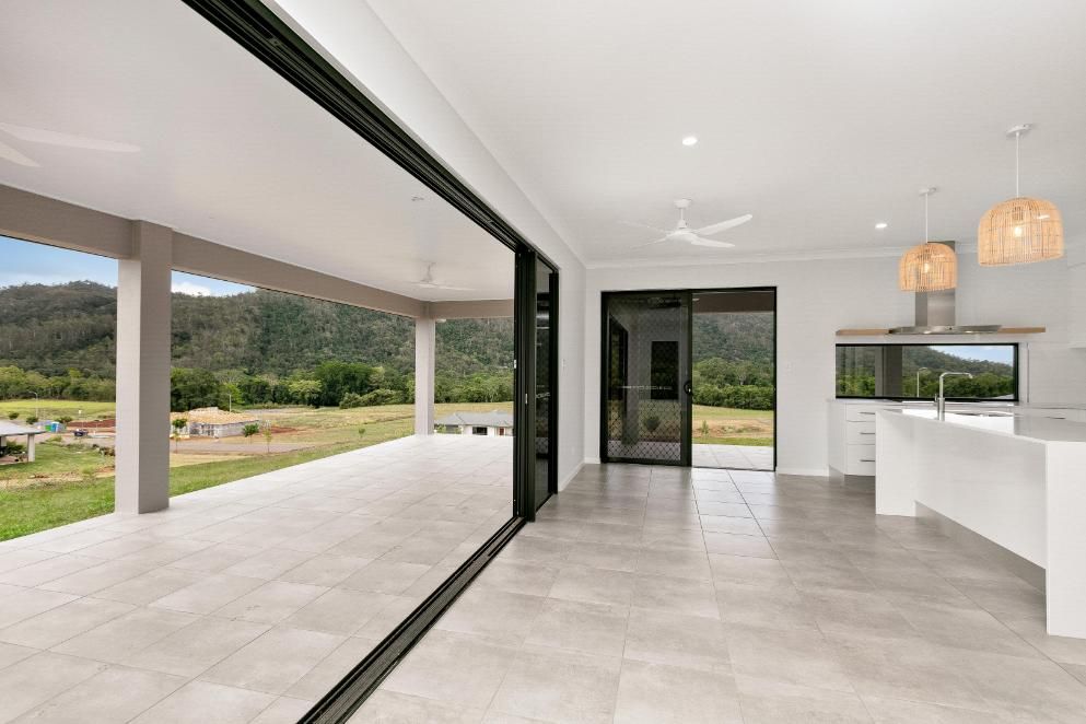 A Kitchen With a Large Sliding Glass Door Leading to a Patio — Ashlee Jones Homes in Gordonvale, QLD