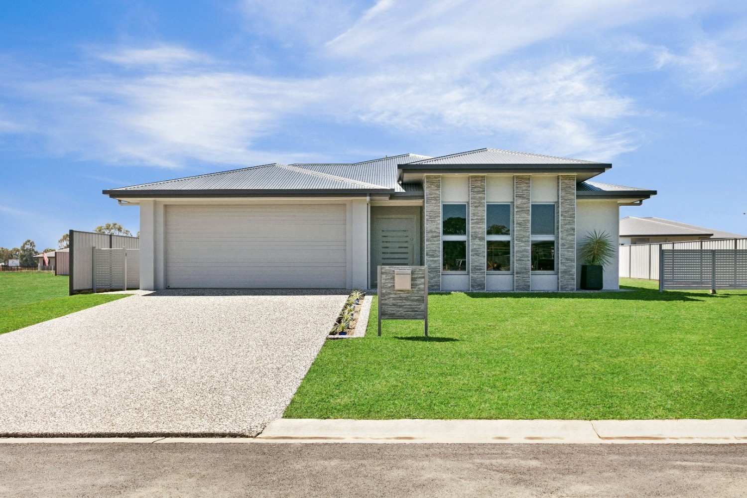 A White House With a Driveway and a Sign in Front of It — Ashlee Jones Homes in Gordonvale, QLD