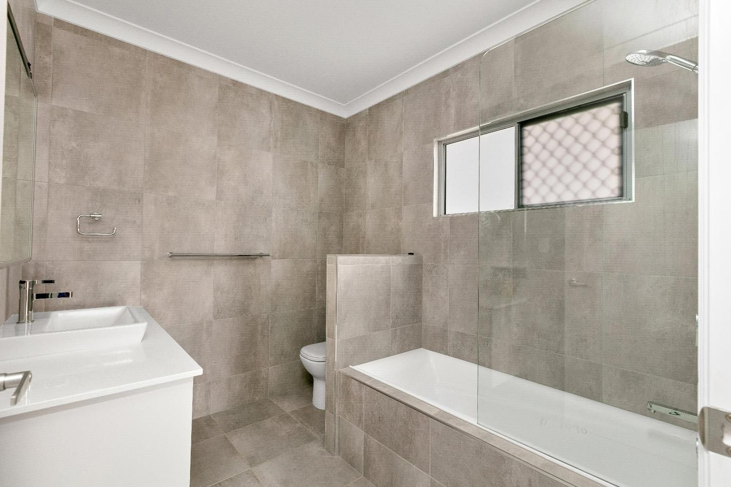 A Bathroom With a Sink, Toilet and Bathtub — Ashlee Jones Homes in Gordonvale, QLD