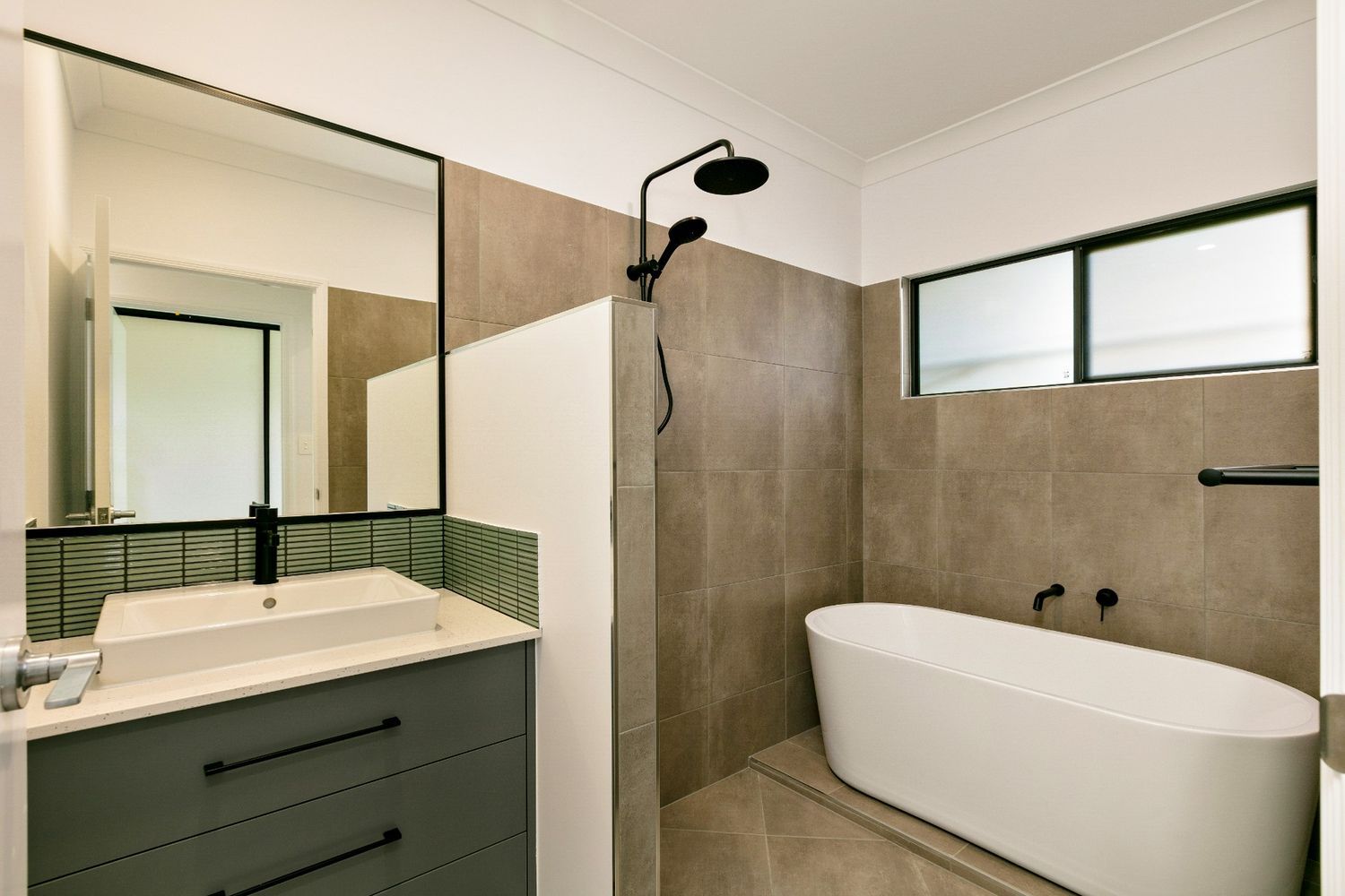 A Bathroom With a Tub, Sink, Mirror and Shower — Ashlee Jones Homes in Gordonvale, QLD