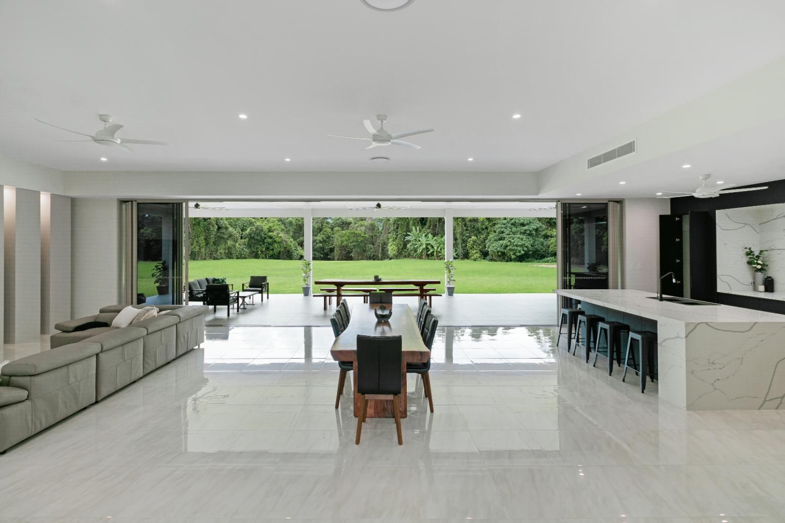 A Large Living Room With a Dining Room Table and Chairs and a Kitchen — Ashlee Jones Homes in Gordonvale, QLD