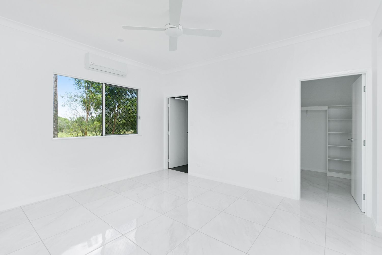 An Empty Room With a Ceiling Fan and Two Windows — Ashlee Jones Homes in Gordonvale, QLD