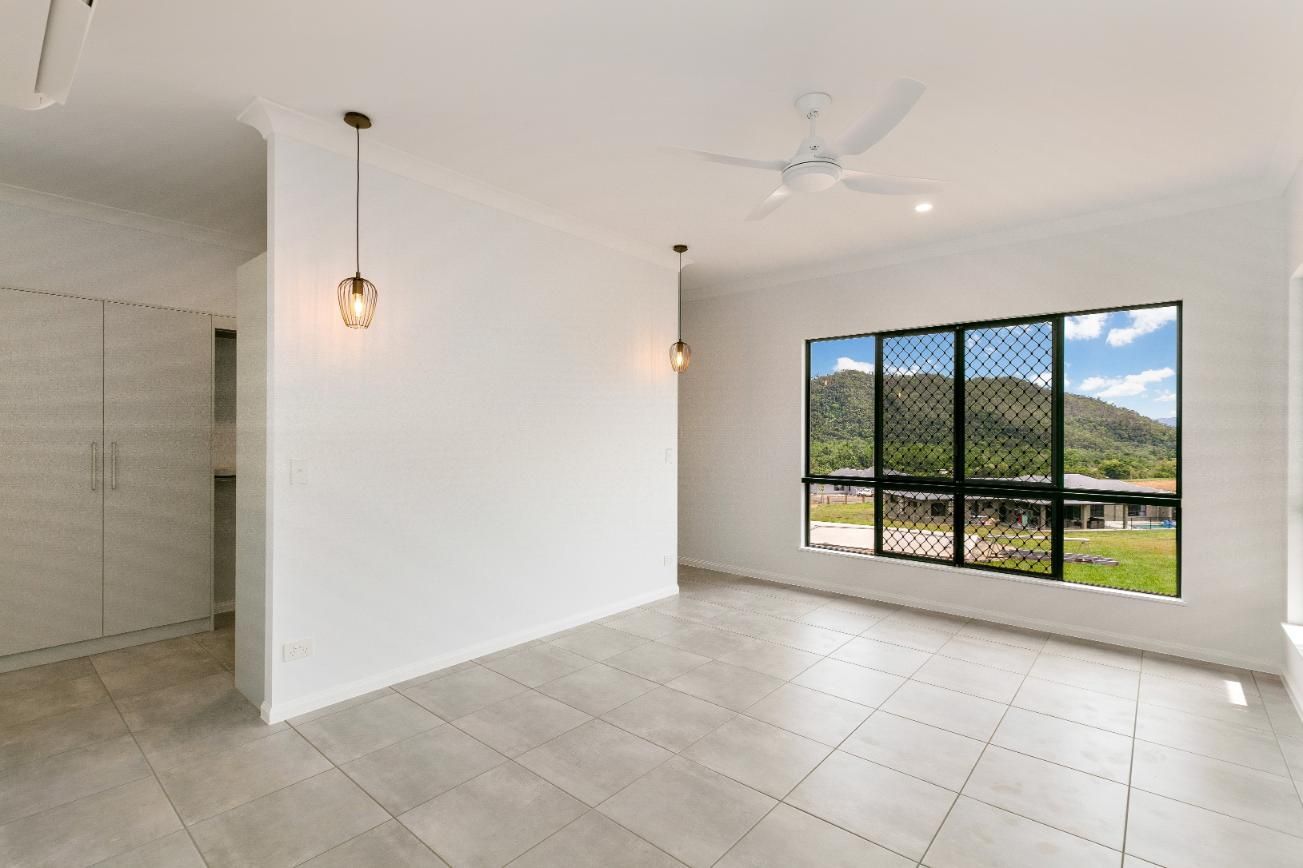 An Empty Living Room With a Large Window and a Ceiling Fan — Ashlee Jones Homes in Gordonvale, QLD