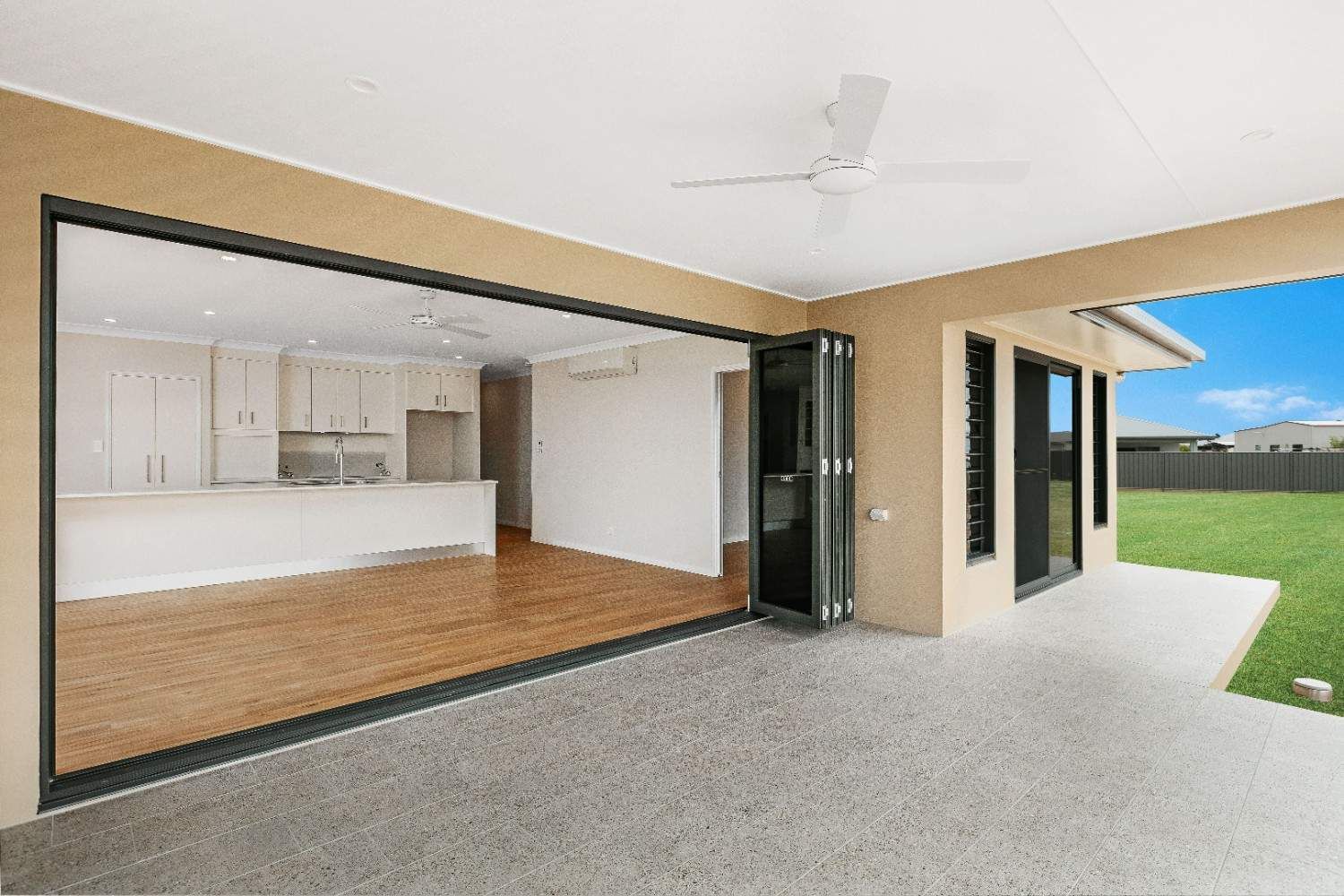 An Empty House With a Large Sliding Glass Door Leading to a Patio — Ashlee Jones Homes in Gordonvale, QLD