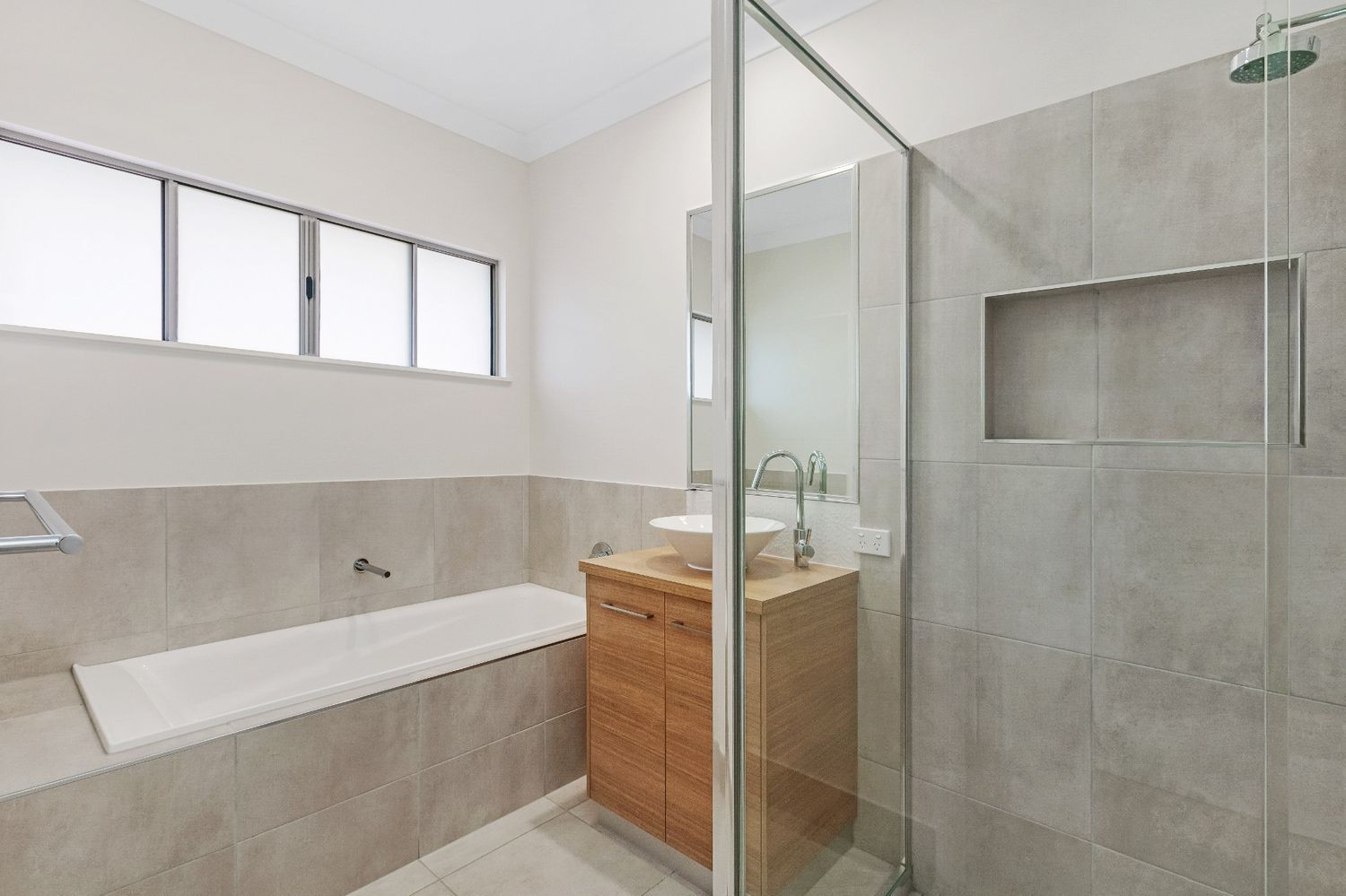 A Bathroom With a Bathtub, Sink, and Shower — Ashlee Jones Homes in Gordonvale, QLD