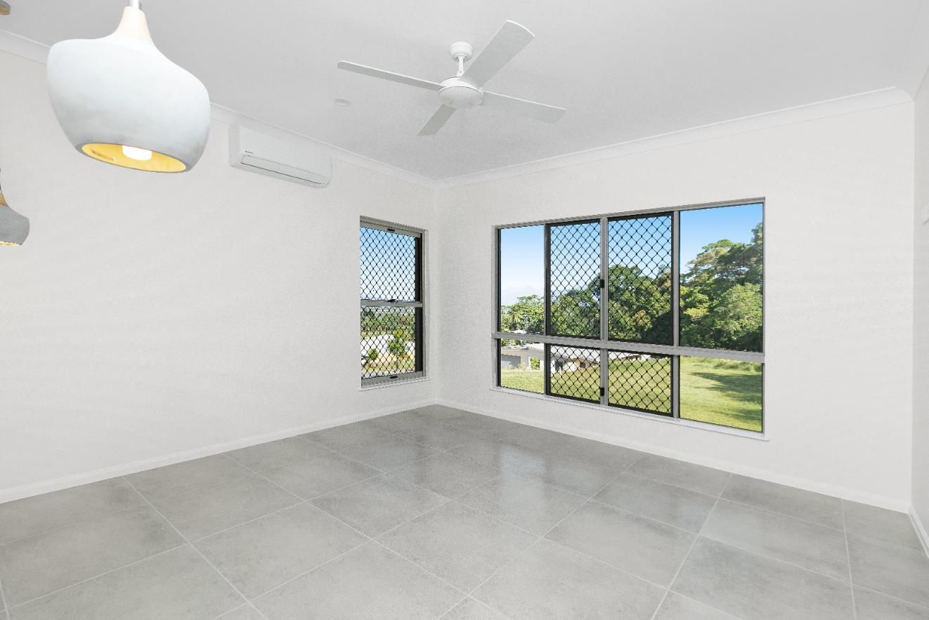 An Empty Room With a Ceiling Fan and a Lot of Windows — Ashlee Jones Homes in Gordonvale, QLD