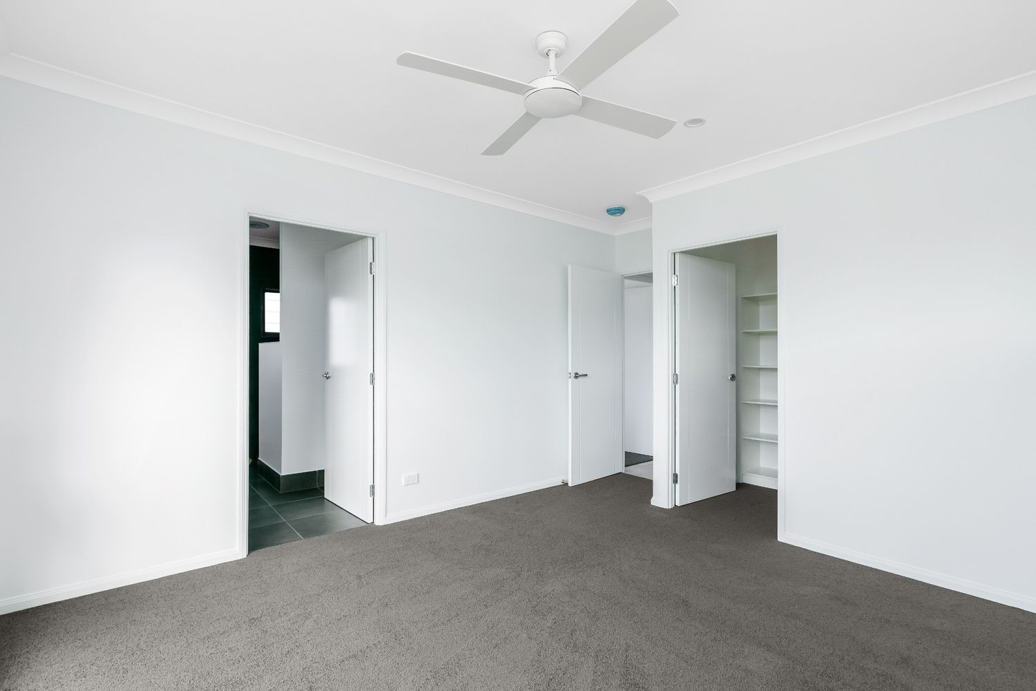 An Empty Bedroom With a Ceiling Fan in the Corner — Ashlee Jones Homes in Gordonvale, QLD