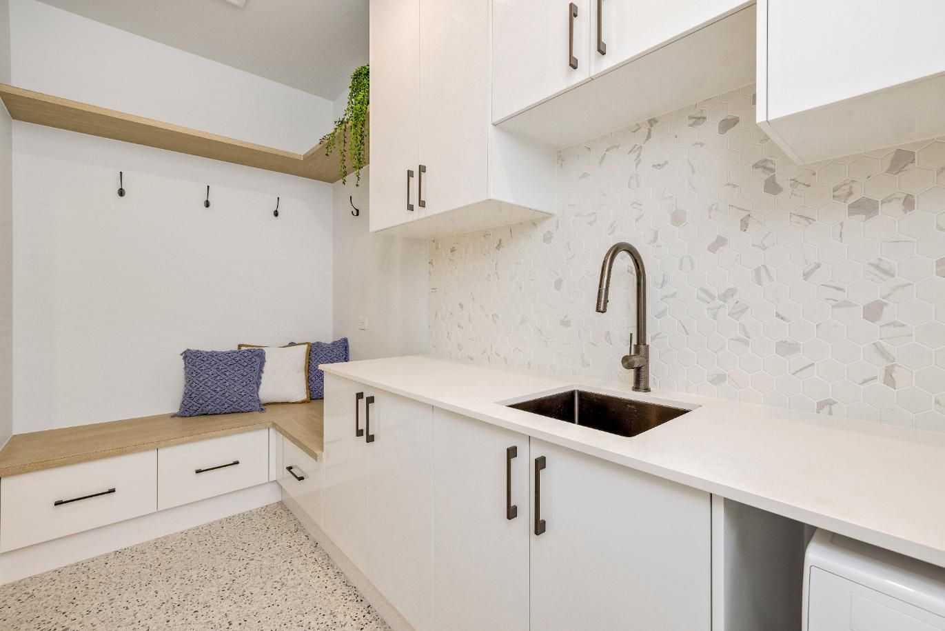A Kitchen With White Cabinets, a Sink, and a Bench — Ashlee Jones Homes in Gordonvale, QLD
